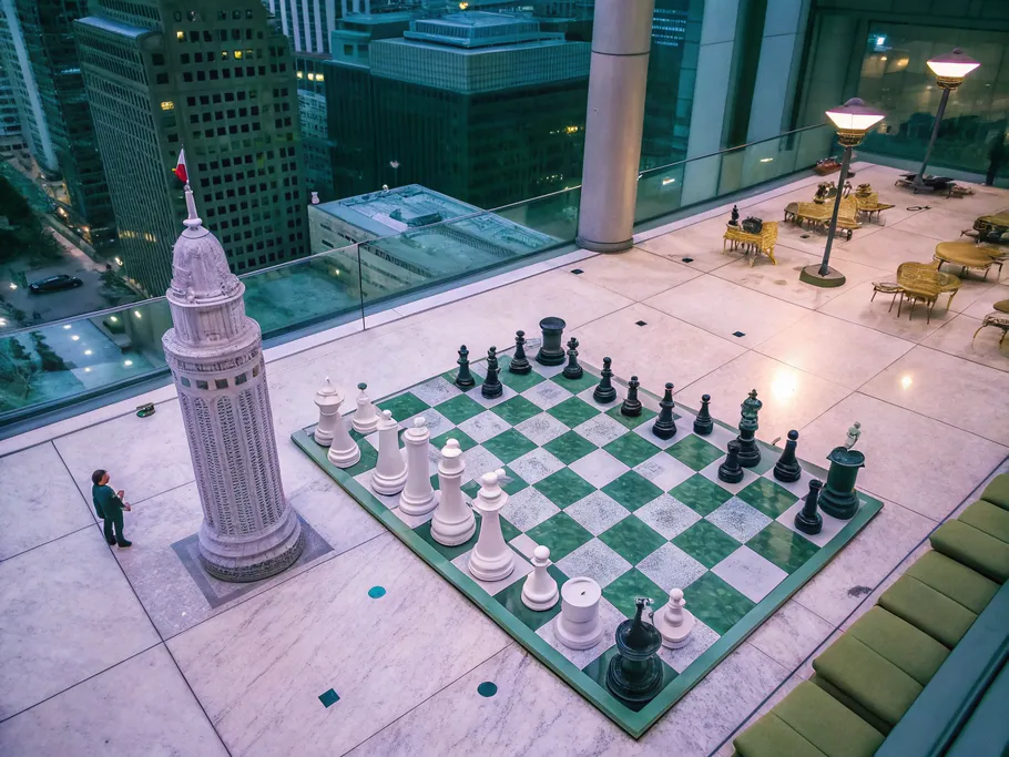 An artistic chess board made of business assets symbolizing strategic tax planning.